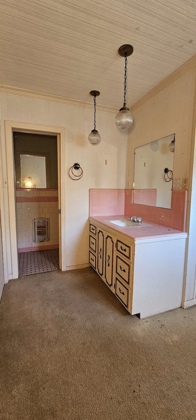 kitchen with sink, crown molding, hanging light fixtures, carpet, and heating unit