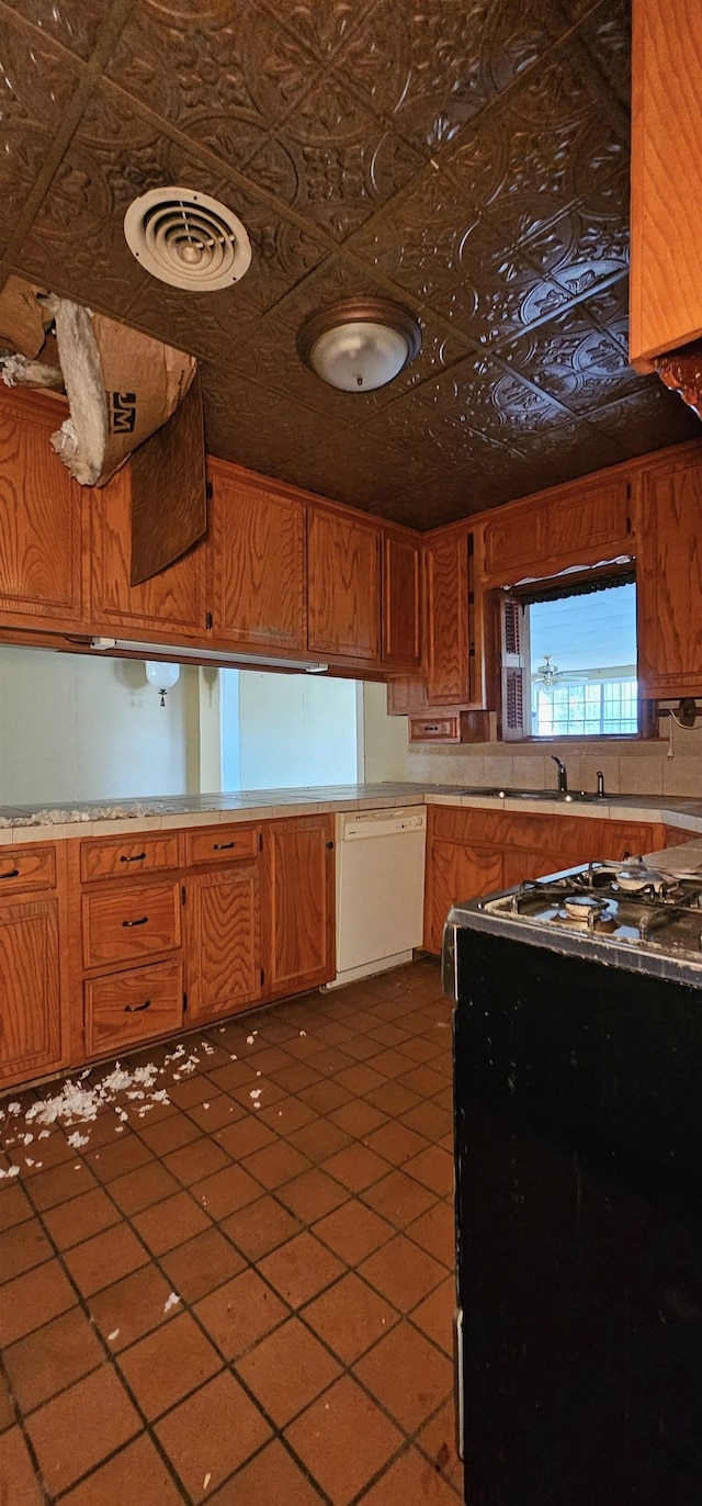 kitchen featuring white dishwasher, sink, and gas stove