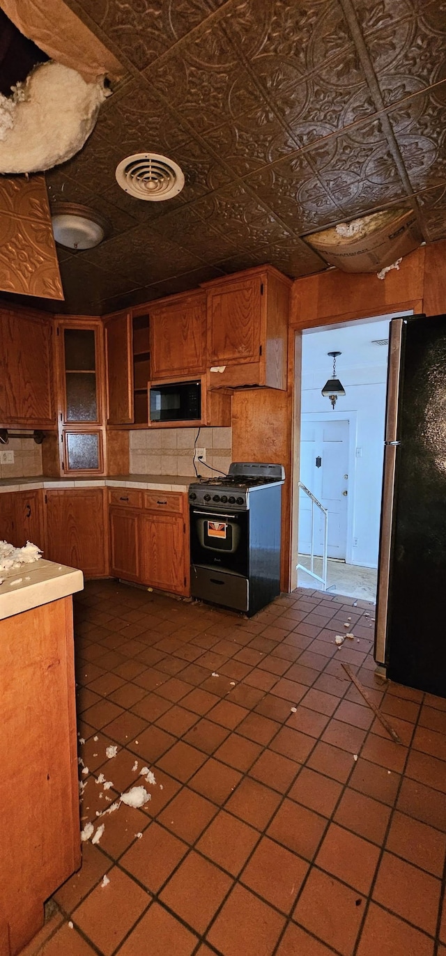 kitchen with dark tile patterned floors and black appliances