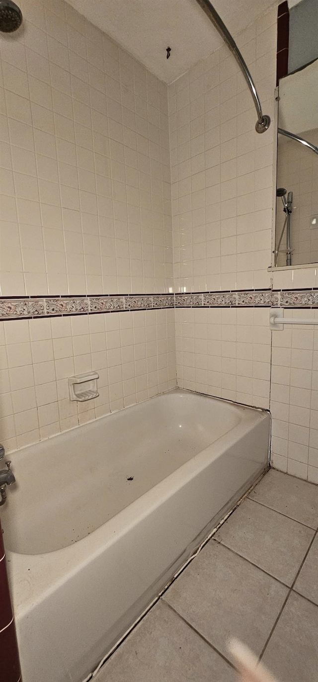 bathroom featuring tile patterned floors, tiled shower / bath combo, and tile walls