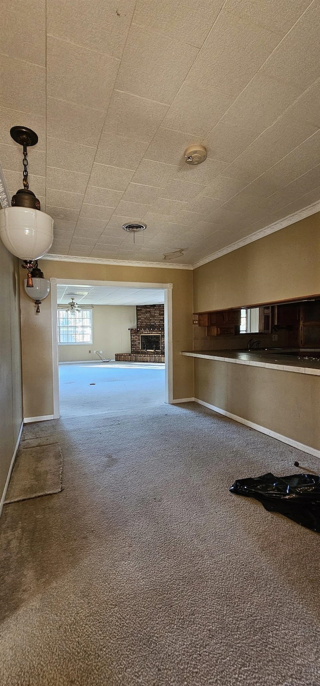 unfurnished living room with ornamental molding and carpet floors