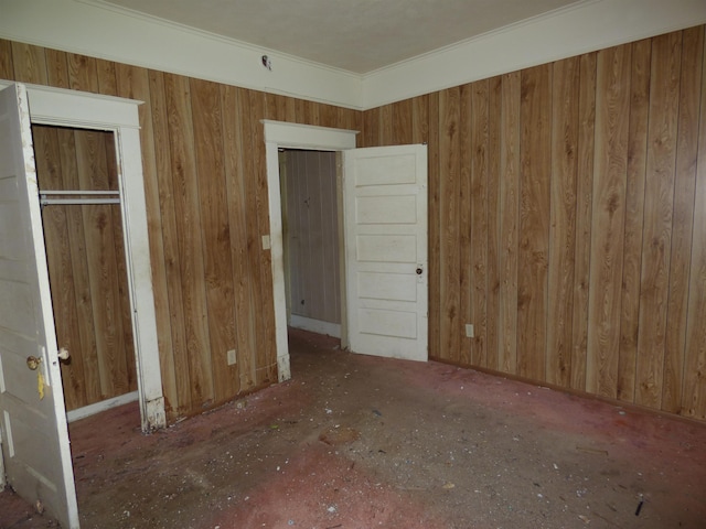 unfurnished bedroom with wooden walls and crown molding