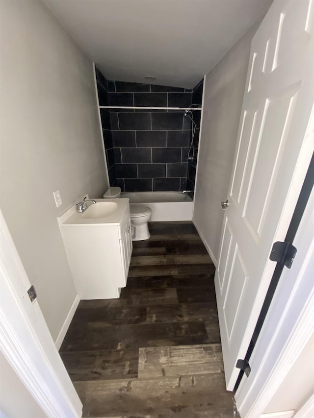 full bathroom with toilet, vanity, hardwood / wood-style flooring, and tiled shower / bath combo