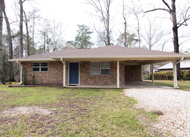 single story home with a front lawn, an attached carport, gravel driveway, roof with shingles, and brick siding