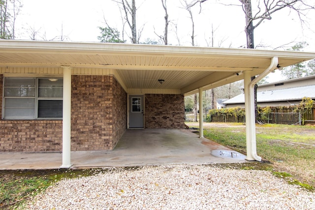 view of patio with a carport, driveway, and fence