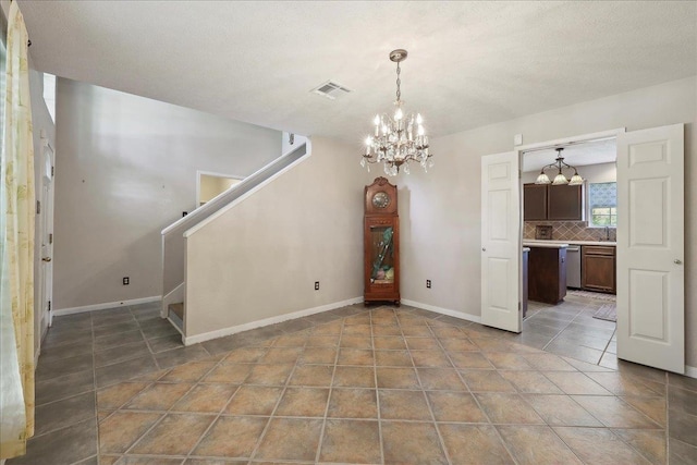 unfurnished dining area with a chandelier, stairs, tile patterned floors, and baseboards