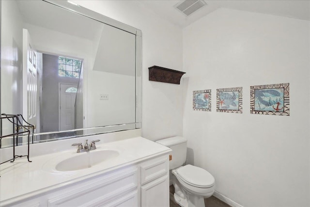 half bathroom with toilet, vanity, and vaulted ceiling