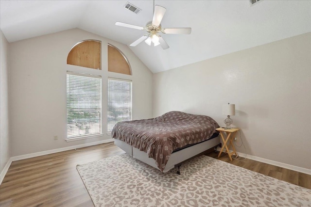 bedroom with lofted ceiling, wood finished floors, baseboards, and a ceiling fan