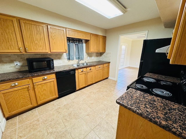 kitchen featuring black appliances, dark stone countertops, sink, and tasteful backsplash