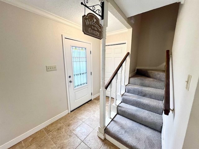 entrance foyer with a textured ceiling and crown molding