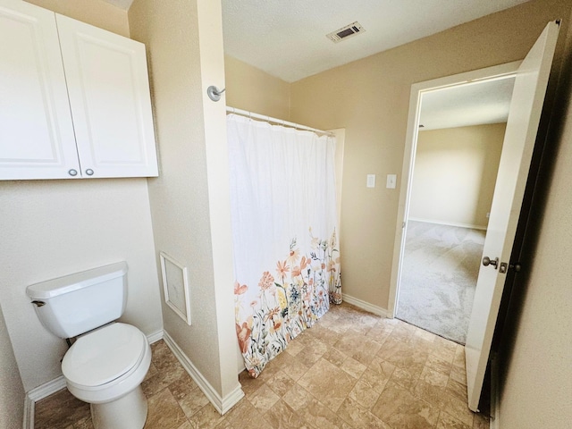 bathroom with a shower with curtain and toilet