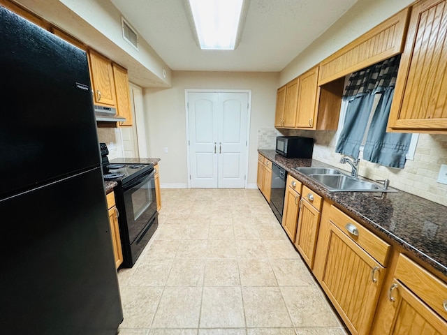 kitchen featuring tasteful backsplash, sink, black appliances, light tile patterned floors, and dark stone countertops