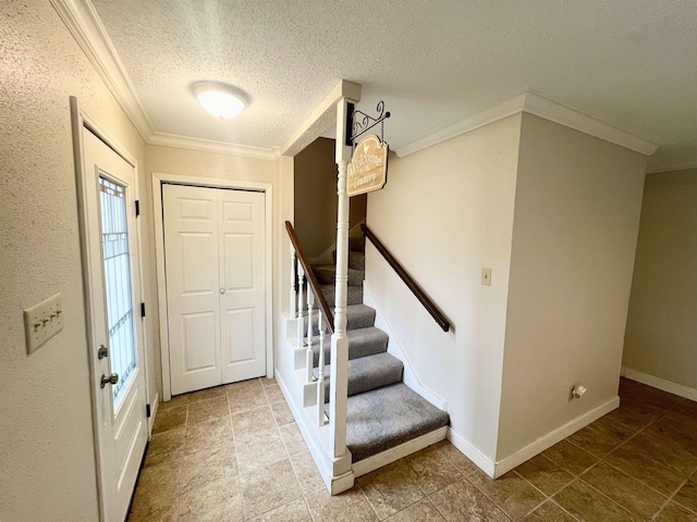 entryway featuring a textured ceiling and crown molding