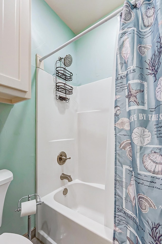 bathroom with toilet and shower / bath combo with shower curtain