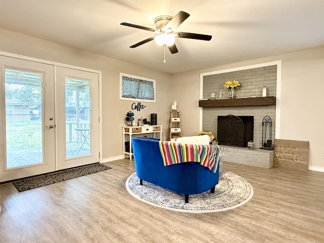 living room featuring ceiling fan, hardwood / wood-style floors, a fireplace, and french doors