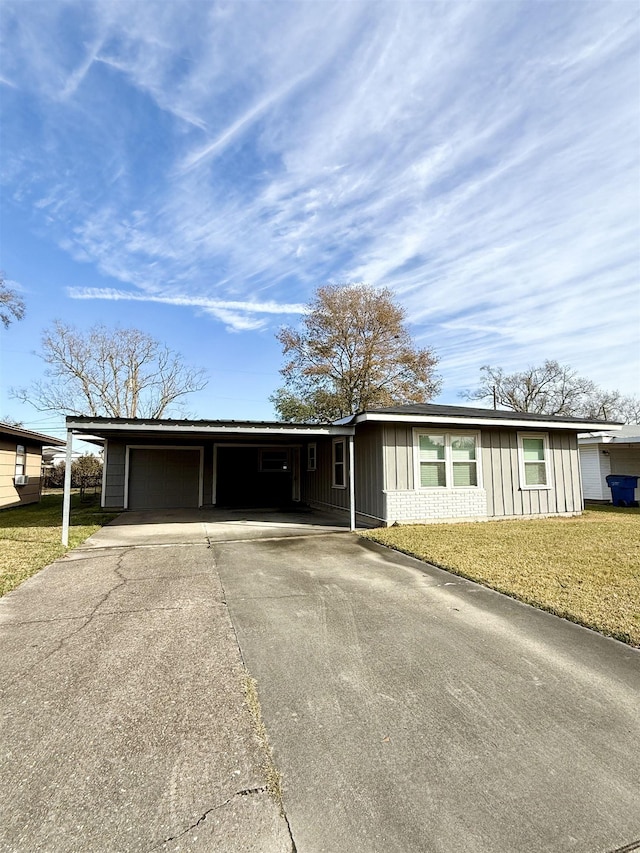 ranch-style house with a carport, a garage, and a front lawn