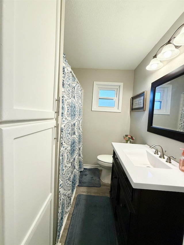 bathroom with vanity, a textured ceiling, and toilet