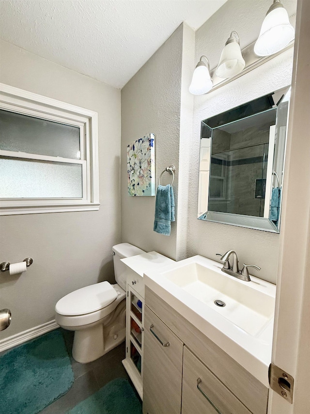 bathroom with vanity, a textured ceiling, and toilet