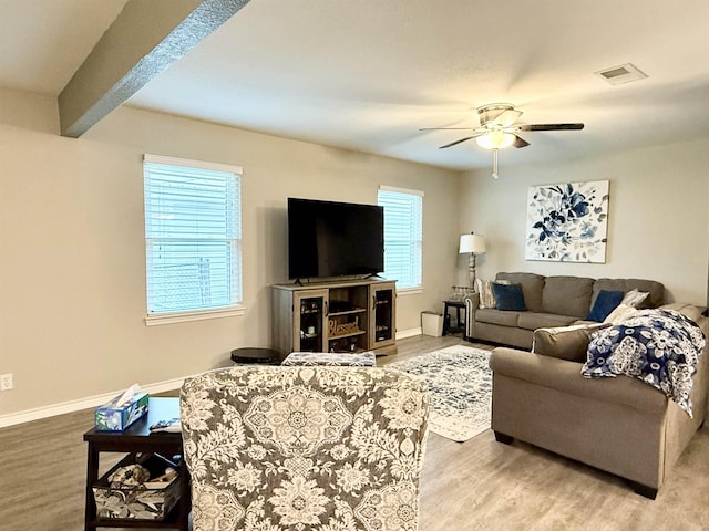 living room featuring beamed ceiling, ceiling fan, and light hardwood / wood-style flooring