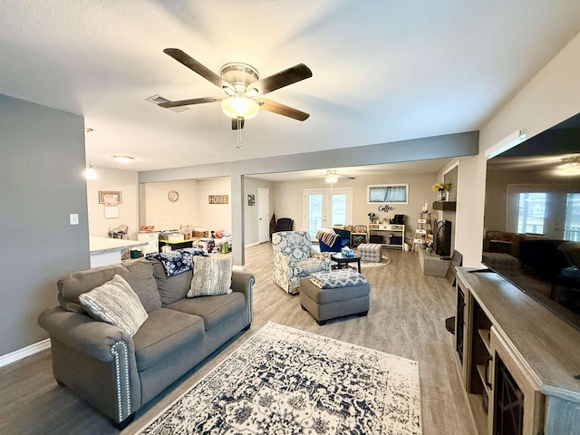 living room featuring ceiling fan and light hardwood / wood-style flooring