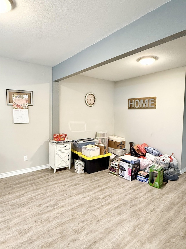 basement with hardwood / wood-style floors and a textured ceiling