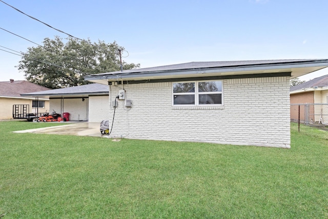 back of house with a lawn and a patio area