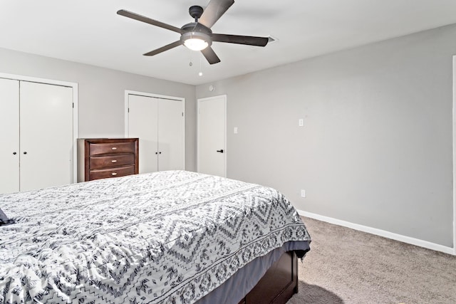 bedroom with multiple closets, ceiling fan, and carpet floors