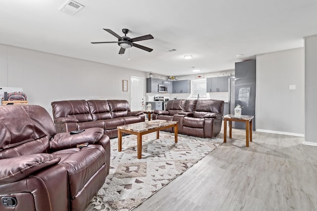 living room featuring ceiling fan and light hardwood / wood-style floors