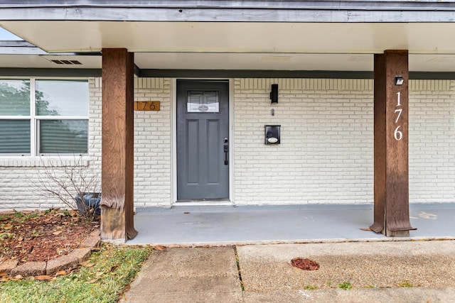 view of exterior entry featuring covered porch