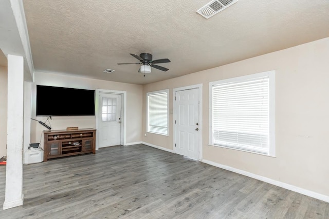 unfurnished living room with ceiling fan, a textured ceiling, and hardwood / wood-style flooring