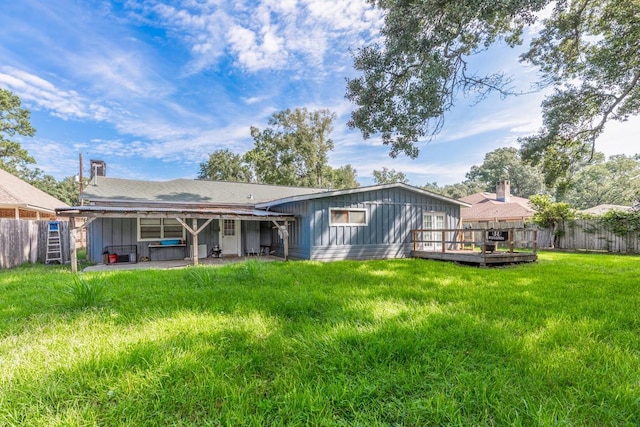 rear view of property with a lawn, a patio area, and a deck