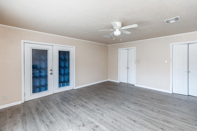 unfurnished room with ceiling fan, french doors, hardwood / wood-style floors, and a textured ceiling