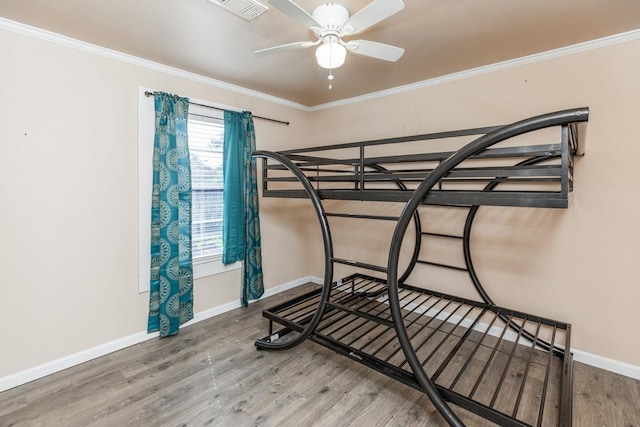 bedroom with ceiling fan, wood-type flooring, and ornamental molding