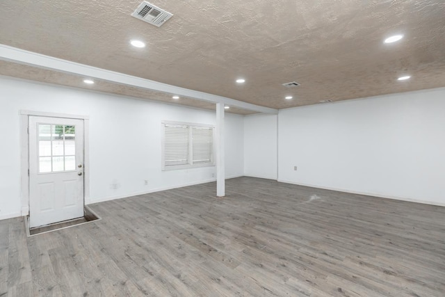 basement with hardwood / wood-style floors and a textured ceiling