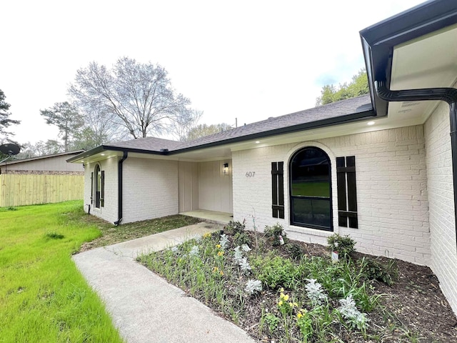 view of exterior entry featuring a lawn