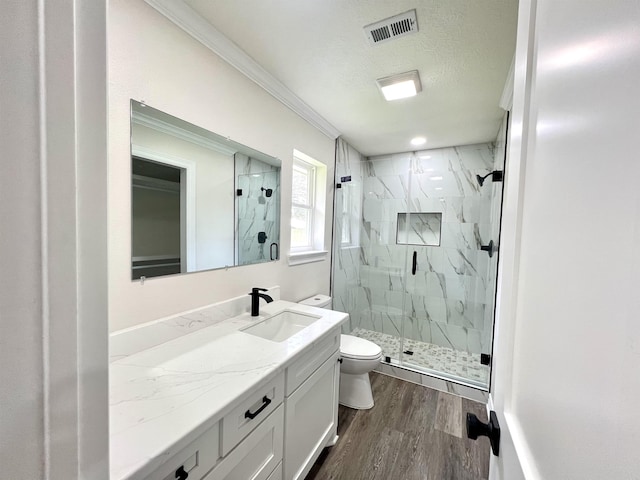 bathroom featuring an enclosed shower, vanity, crown molding, hardwood / wood-style floors, and toilet