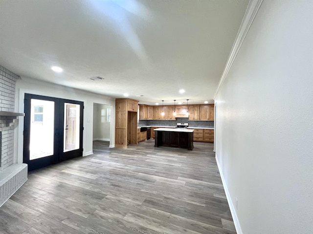 kitchen featuring decorative backsplash, french doors, ornamental molding, decorative light fixtures, and a center island