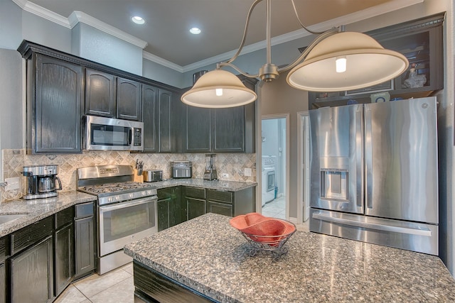 kitchen featuring backsplash, dark stone countertops, decorative light fixtures, light tile patterned flooring, and stainless steel appliances