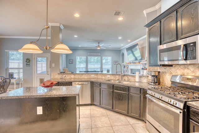 kitchen with light stone countertops, appliances with stainless steel finishes, ceiling fan, sink, and pendant lighting