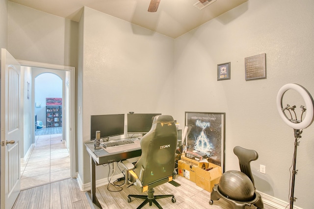 home office with ceiling fan and light hardwood / wood-style flooring