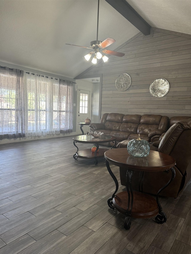 living room with vaulted ceiling with beams, a healthy amount of sunlight, ceiling fan, and wood-type flooring