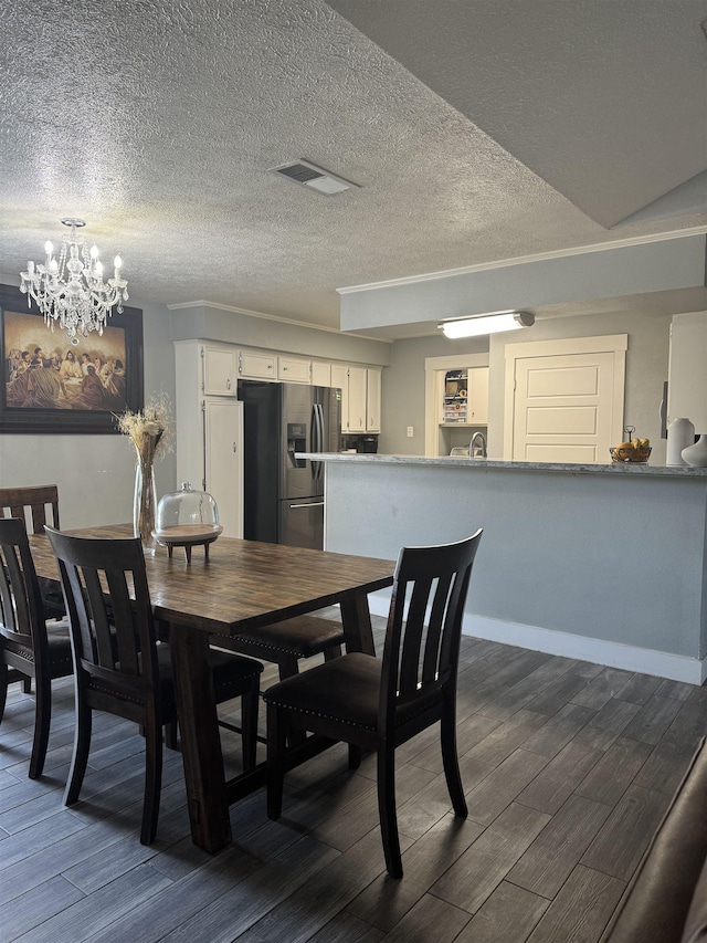 dining area with a chandelier and a textured ceiling