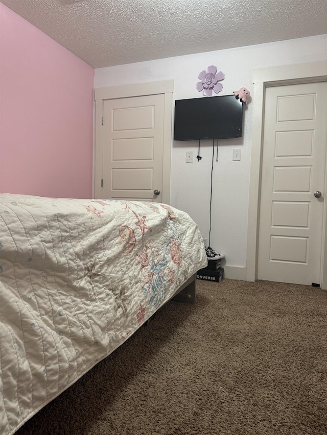 carpeted bedroom with a closet and a textured ceiling