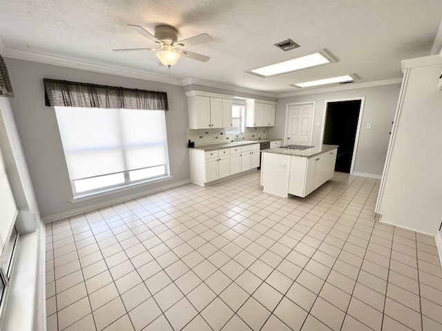 kitchen featuring light tile patterned floors, visible vents, dishwashing machine, crown molding, and a sink