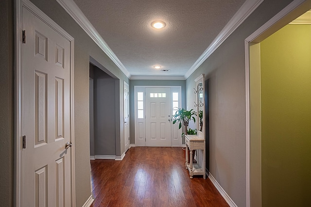 entrance foyer featuring a textured ceiling, ornamental molding, dark wood finished floors, and baseboards