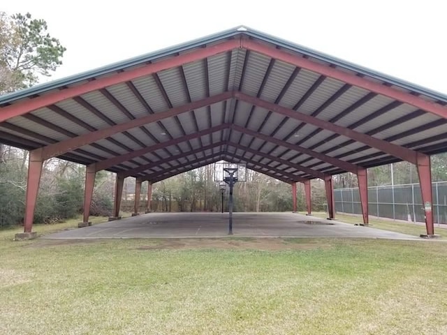 view of property's community featuring a carport, a lawn, and fence