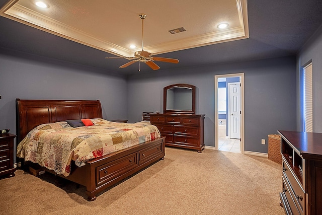 bedroom with visible vents, a tray ceiling, crown molding, and light colored carpet