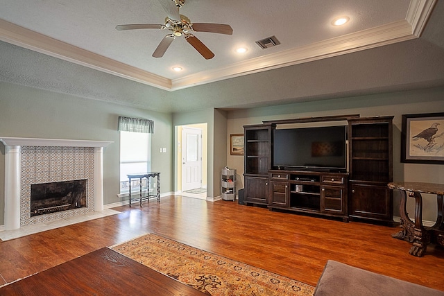 unfurnished living room featuring a fireplace, visible vents, crown molding, and wood finished floors