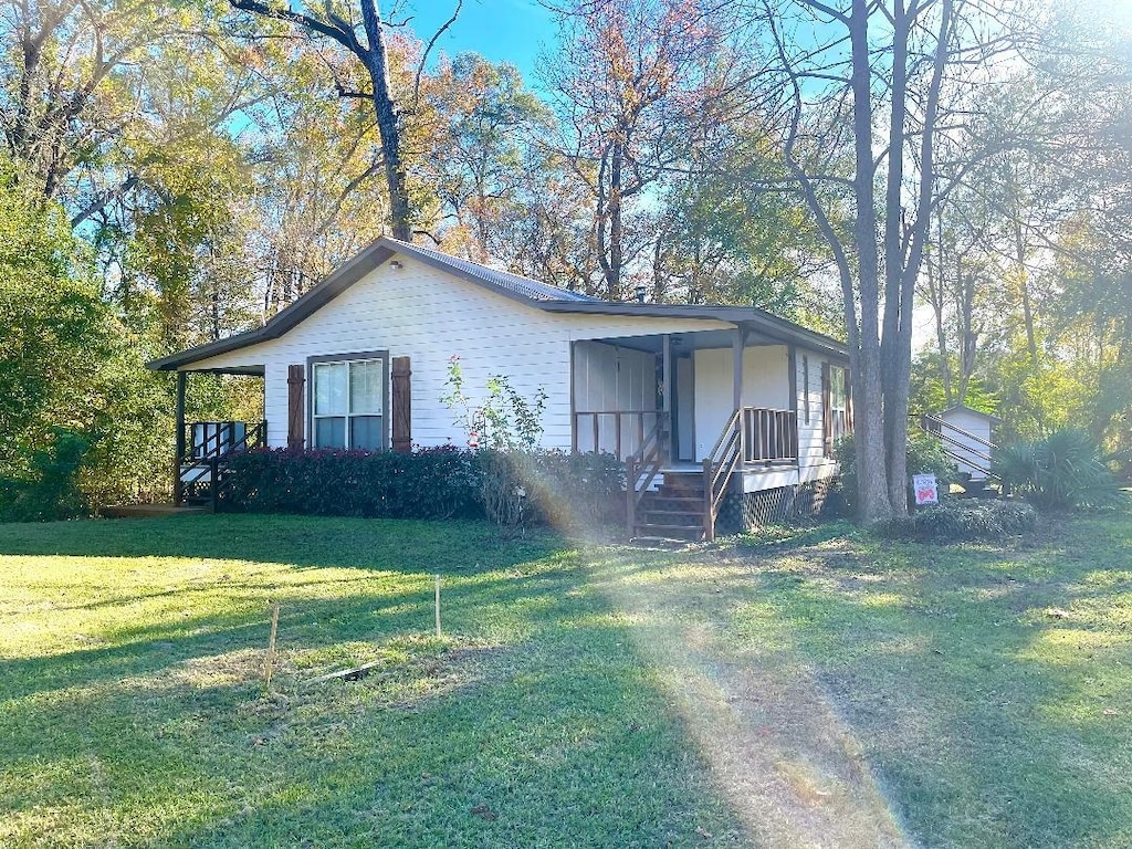 view of front of home with a porch and a front lawn