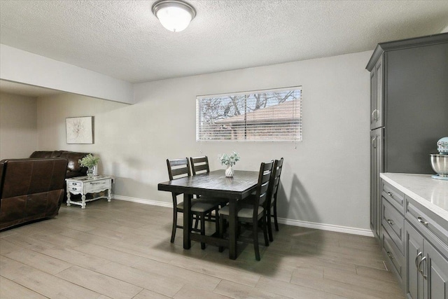 dining area featuring light hardwood / wood-style flooring and a textured ceiling